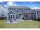 Wide view of the home's backyard with an outdoor dining and fire pit area at 136 Morgans Branch Rd, Belmont, NC 28012