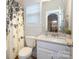 Bright bathroom featuring a granite countertop, large mirror, and tub-shower combo at 136 Morgans Branch Rd, Belmont, NC 28012