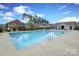 Large community pool surrounded by lounge chairs and a neighboring recreation center at 136 Morgans Branch Rd, Belmont, NC 28012