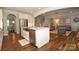 Bright kitchen featuring a large island, stainless appliances, white cabinetry, and view into living room at 136 Morgans Branch Rd, Belmont, NC 28012