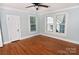 Light-filled bedroom featuring hardwood floors, ceiling fan, and multiple windows at 1460 Legion Club Rd, Salisbury, NC 28146