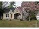 Charming stone home with covered porch and blooming tree in yard at 1460 Legion Club Rd, Salisbury, NC 28146