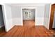 Open living room with hardwood floors leading to another room with white wainscoting at 1460 Legion Club Rd, Salisbury, NC 28146