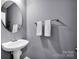 Modern powder room features a pedestal sink, a decorative mirror, and chrome fixtures at 14921 Baldridge Dr, Huntersville, NC 28078