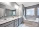 Spacious bathroom with double sinks, white cabinets, a large mirror, a tub, and a glass enclosed shower at 14921 Baldridge Dr, Huntersville, NC 28078
