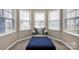 Bedroom alcove featuring multiple windows, a gray upholstered chair, and a blue ottoman at 14921 Baldridge Dr, Huntersville, NC 28078