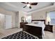 Well-lit bedroom featuring a plush carpet, a ceiling fan, and a dark wood bed with a patterned black and white rug at 14921 Baldridge Dr, Huntersville, NC 28078