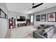 Comfortable bedroom with a ceiling fan, a wall-mounted tv, a gray sectional, and movie posters at 14921 Baldridge Dr, Huntersville, NC 28078