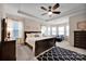 Spacious bedroom featuring a trey ceiling, a ceiling fan, lots of windows, and a large dark wood bed frame at 14921 Baldridge Dr, Huntersville, NC 28078