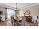 Dining room featuring wood flooring, modern light fixture, and a rustic wooden table at 14921 Baldridge Dr, Huntersville, NC 28078