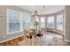 Inviting dining area features natural light from the bay window, wood floors, and modern chandelier at 14921 Baldridge Dr, Huntersville, NC 28078