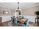 Inviting dining room with hardwood floors, modern light fixture, and a large wooden table at 14921 Baldridge Dr, Huntersville, NC 28078