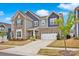 Beautiful two-story home with stone and siding exterior and a well-manicured lawn on a sunny day at 14921 Baldridge Dr, Huntersville, NC 28078