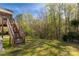 Backyard view featuring steps to the screened-in porch with a lush lawn and mature trees at 1527 Meadow Glen Ln, Rock Hill, SC 29730