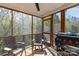 Covered screened-in porch with seating, wooded view and grill for enjoyable outdoor living at 1527 Meadow Glen Ln, Rock Hill, SC 29730