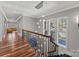 Hallway featuring hardwood floors, custom railing, and a stylish chandelier at 1754 Brawley School Rd, Mooresville, NC 28117
