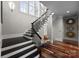 Staircase has wooden steps and floors, with black railings and bright lighting fixtures at 1754 Brawley School Rd, Mooresville, NC 28117