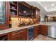 An elegant basement bar featuring wood cabinets, granite countertops, and a built-in beverage cooler at 200 Highland Forest Dr, Charlotte, NC 28270