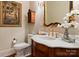 Ornate powder room featuring a marble countertop, gold fixtures, and decorative mirror at 200 Highland Forest Dr, Charlotte, NC 28270
