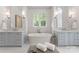 Elegant bathroom featuring dual vanities, a soaking tub, marble accents, and a window offering natural light at 200 Highland Forest Dr, Charlotte, NC 28270