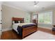 Comfortable bedroom with a wooden bed frame, matching dresser, and bright windows providing natural light and garden views at 200 Highland Forest Dr, Charlotte, NC 28270