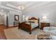 Generously sized bedroom with wood floors features a tray ceiling and a relaxing sitting area near a window at 200 Highland Forest Dr, Charlotte, NC 28270