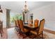 Formal dining room with traditional wood table, decorative rug, and large window showcasing the landscaped outdoors at 200 Highland Forest Dr, Charlotte, NC 28270