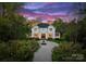 Serene view of a stately home with a water fountain and perfectly manicured landscaping at dusk at 200 Highland Forest Dr, Charlotte, NC 28270