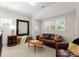 Cozy living area featuring a leather sofa, ottoman, and large framed artwork, perfect for relaxation and intimate gatherings at 200 Highland Forest Dr, Charlotte, NC 28270