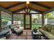Cozy screened-in patio with comfortable seating, ceiling fan, and views of the lush garden and stone steps at 200 Highland Forest Dr, Charlotte, NC 28270