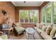 Cozy sunroom featuring exposed brick walls, comfortable seating, and a large window for ample natural light at 200 Highland Forest Dr, Charlotte, NC 28270