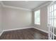The bedroom has hardwood floors, white trim, and a large window with blinds at 2097 Saddlebred Dr, Iron Station, NC 28080