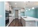 Open kitchen with island, white cabinets, and stainless steel appliances at 2097 Saddlebred Dr, Iron Station, NC 28080