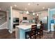 Well-lit kitchen offering stainless steel appliances, white cabinets, and a large island with bar seating at 2097 Saddlebred Dr, Iron Station, NC 28080