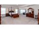 Spacious primary bedroom with a four-poster bed and adjoining sitting area at 2097 Saddlebred Dr, Iron Station, NC 28080