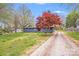 A quaint one-story home with colorful landscaping and mature trees at 2109 Tarlton Dr, Matthews, NC 28105