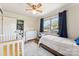 Bright bedroom boasts a crib, twin bed, wood floors, large window and blue curtains at 237 Palaside Ne Dr, Concord, NC 28025
