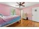 Pink bedroom features wood floors, ceiling fan, window with curtains, and chest of drawers at 237 Palaside Ne Dr, Concord, NC 28025