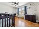 Bright Bedroom features wood floors, ceiling fan, window with blue curtains and baby furniture at 237 Palaside Ne Dr, Concord, NC 28025