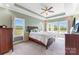 Large bedroom featuring tray ceilings, ceiling fan and many windows for natural light at 244 Alexis Lucia Rd, Alexis, NC 28006
