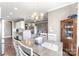 Bright dining room features an elegant chandelier, wooden table with white chairs, and wood flooring at 244 Alexis Lucia Rd, Alexis, NC 28006