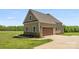 A detached two-car garage echoes the architectural style of the main house with matching siding and stone accents at 244 Alexis Lucia Rd, Alexis, NC 28006
