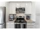 Well-equipped kitchen features a stainless steel oven, microwave, and granite counters and white cabinets at 244 Alexis Lucia Rd, Alexis, NC 28006