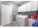 Functional laundry room features overhead cabinets, a side cabinet, and white washer and dryer at 244 Alexis Lucia Rd, Alexis, NC 28006