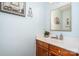 Traditional half bathroom with a wooden vanity, white countertop, decor, and framed bath print at 2512 Pimpernel Rd, Charlotte, NC 28213