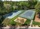 Aerial view of community tennis courts and a playground nestled among lush trees and landscaping at 2906 Crescent Knoll Dr, Matthews, NC 28105