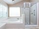 Bright bathroom with shower, soaking tub, and tiled surround at 2906 Crescent Knoll Dr, Matthews, NC 28105