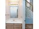 Bathroom featuring a single vanity, mirror, and lighting fixture, with wallpaper and staircase at 2906 Crescent Knoll Dr, Matthews, NC 28105