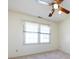 A bright bedroom featuring a ceiling fan and a large window with pleated shades at 2906 Crescent Knoll Dr, Matthews, NC 28105