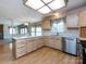 Well-equipped kitchen with light wood cabinetry, laminate wood flooring, stainless steel appliances, and breakfast bar at 2906 Crescent Knoll Dr, Matthews, NC 28105